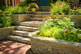 brick walkway leading up to stone steps and surrounded by multilevel stone garden walls